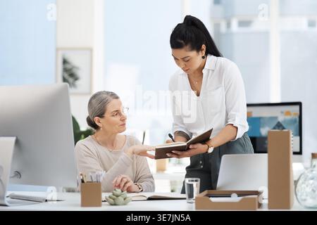 Team, business people and writing notes in meeting for feedback, training or help with journalist. Notebook, planning and women in office for coaching Stock Photo