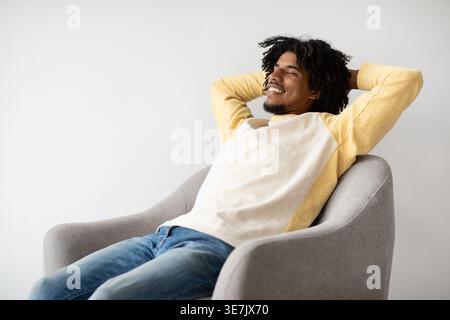Life Is Good. Closeup Portrait Of Young Black Man Relaxing In Armchair At Home, Pleased Afican American Guy Sitting In Chair With Hands Behind Head An Stock Photo