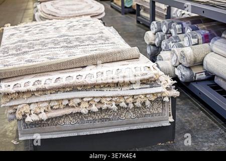 Various carpet samples with textures and patterns on the table and shelves Stock Photo