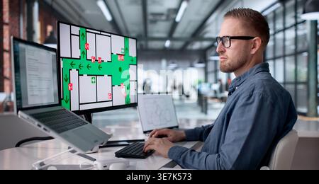 Office Fire Safety Inspector Verifying Alarm Function For Evacuation Readiness Stock Photo