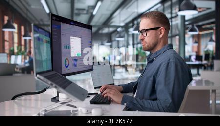 Young Professional Managing Cloud-Based Enterprise Software System On Laptop Stock Photo