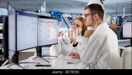 Factory Manager Monitors Real-time Production Tracking On Multiple Screens. Stock Photo