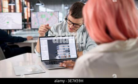 Architect Leads Team Discussing 3D BIM Model During Important Project Meeting. Stock Photo
