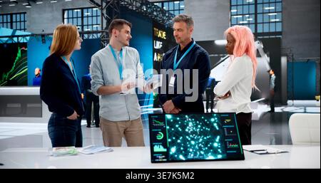 Corporate Team Discussing Marketing Strategy At Vibrant International Business Fair. Stock Photo