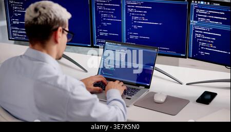 Hispanic Software Developer Working On Coding And Cybersecurity Solutions In Office Environment Stock Photo