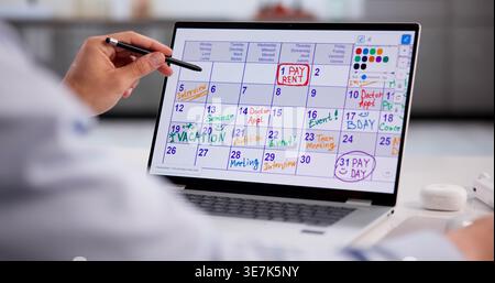 Hispanic Businessman Scheduling Tasks And Taking Notes On Laptop For Project Planning Stock Photo
