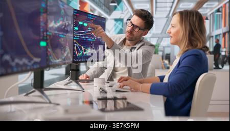 Financial Analysts Reviewing Diverse Market Data On Multiple Screens In Office Setting Stock Photo
