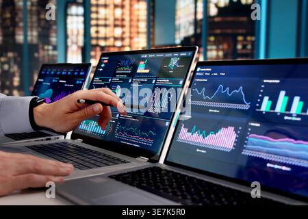 Hispanic Data Analyst Reviewing Business Performance Dashboard Late At Office Stock Photo