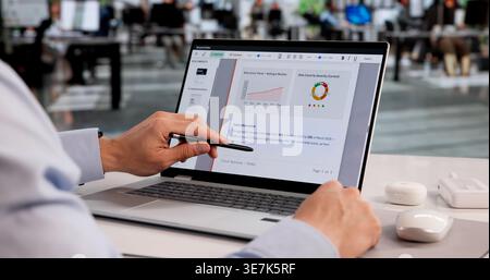 Young Latino Man Reviewing And Approving Documents Using Cloud Software With Checklist On Laptop Stock Photo
