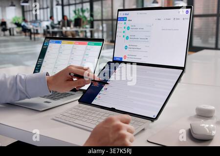 Young Hispanic Business Professional Reviewing Emails On Laptop At Office Desk Stock Photo