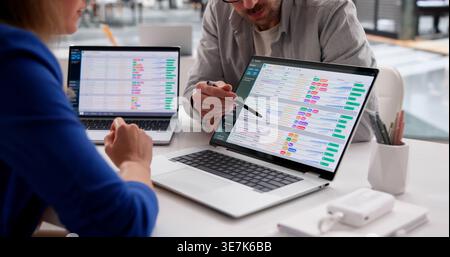 Medical Researcher Analyzes Dual Spreadsheets On Laptop In Office Setting Stock Photo