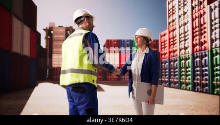 Business Professionals Sealing A Deal With A Handshake At A Bustling Shipping Terminal Stock Photo