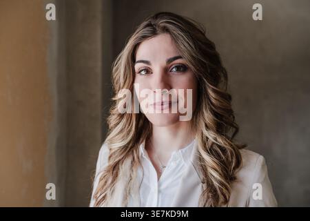 Serious Hispanic female architect standing in construction site during daytime Stock Photo