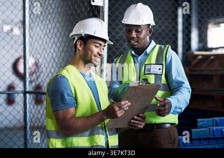 Happy, businessmen and contractor with clipboard in warehouse for logistics or inventory checklist. Male people, employees or checking supply chain Stock Photo