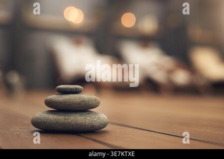 Spa, bokeh and zen stones on floor, relax and hospitality with people on vacation at luxury resort. Rocks, therapy and salon for treatment with stack Stock Photo