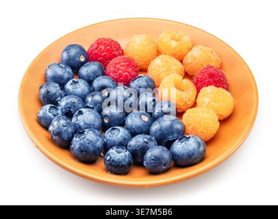 Fresh berry assortment with yellow and red raspberries and blueberries served on a ceramic orange color plate, isolated on a white background. Concept Stock Photo
