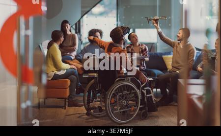 Diverse group of business people with disabled caucasian businessman using VR goggles and drone assistance simulation while having a meeting in the... Stock Photo