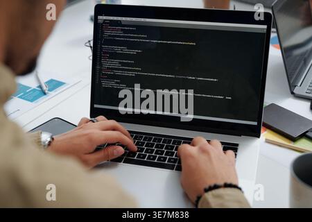 Middle Eastern man working on laptop sitting at table together in office Stock Photo