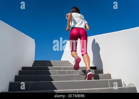 Woman doing run up on staircase Stock Photo