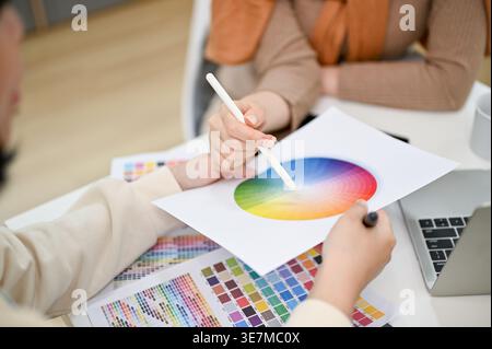 Asian female graphic designers working on their new design project while sitting at table in office Stock Photo