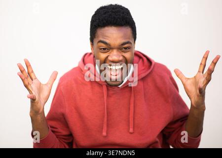 Black male with hands and mouth open standing against white background Stock Photo