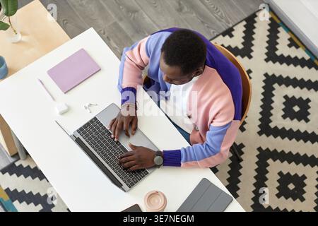 High angle view of Black man working on laptop sitting at desk in office Stock Photo