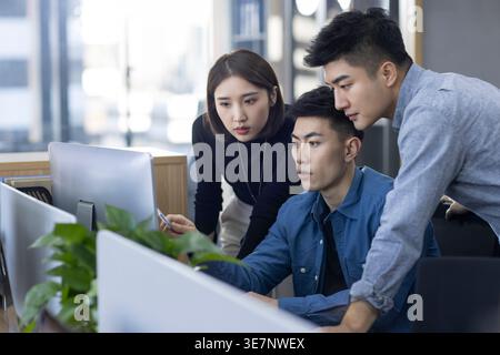 Chinese IT experts working together on computer in office Stock Photo