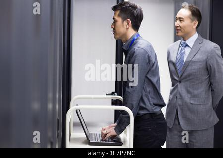Chinese male technicians doing maintenance in computer room Stock Photo