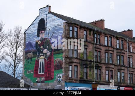 Bagpiper mural by Dan McDermott on tenement building, Scottish bagpiper in kilt street art, Cardonald, Glasgow, Scotland. Stock Photo