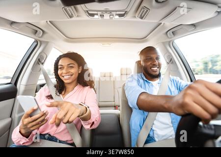 Smiling Black couple riding car together in city Stock Photo