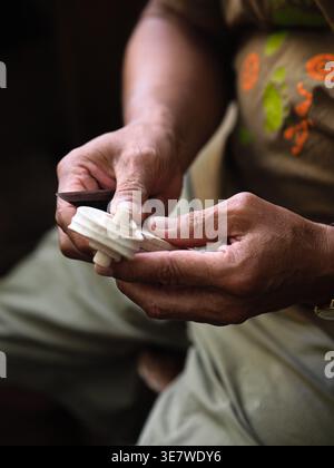 Hispanic male luthier carving working on violin scroll in workshop Stock Photo