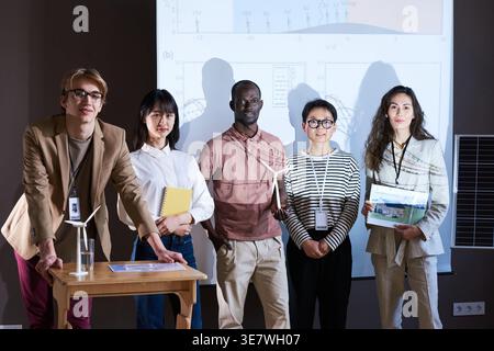 Diverse group of architects standing in front near projector in conference room Stock Photo