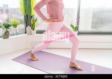 Asian woman doing leg workout using resistance band Stock Photo