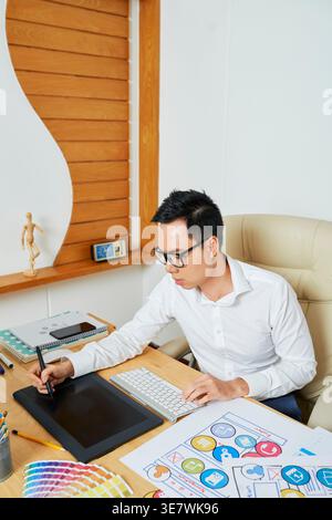 UI designer using graphic tablet when when drawing set of icons for new mobile application Stock Photo
