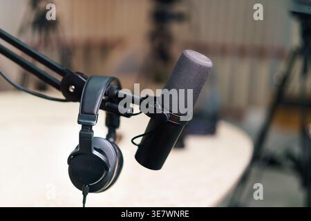 Podcast microphone headphones laptop smartphone Modern audio recording setup digital media production interior workplace Creative content creation sta Stock Photo