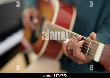 Black woman playing guitar sitting in music room Stock Photo