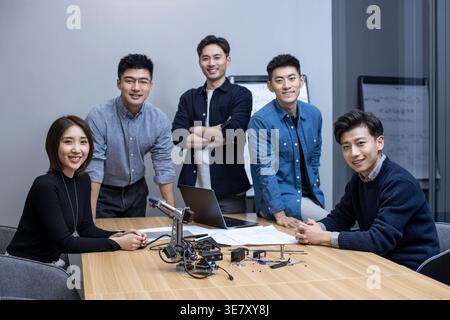 Chinese IT experts working together on their new invention in office Stock Photo