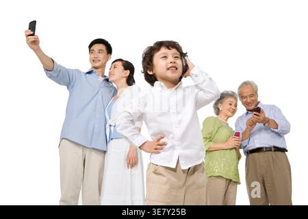 Chinese boy having phone call with family using smartphones standing against white background in studio Stock Photo