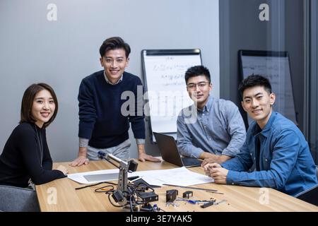 Chinese IT experts working together on their new invention in office Stock Photo