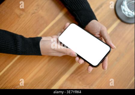 Asian female using smartphone while sitting at table in office Stock Photo