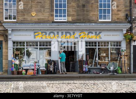 A man stands outside the Proudlock House and Home shop, looking at items displayed on the pavement Stock Photo