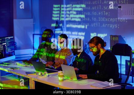 Diverse group of programmers using computers working together sitting at table in offce Stock Photo