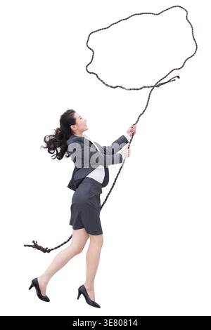 Chinese business woman looking up holding rope standing against white background in studio Stock Photo