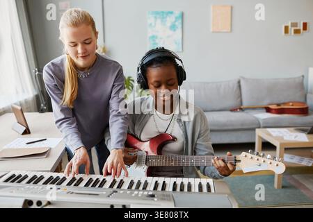 Diverse female musicians playing instruments in studio Stock Photo