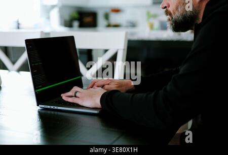 Vibe Coding Software Engineer Developing Billion Dollar Applications at Kitchen Table on Saturday Morning - AI Vibe Coder Concept Stock Photo