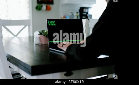 Vibe Coding Software Engineer Developing Billion Dollar Applications at Kitchen Table on Saturday Morning - AI Vibe Coder Concept Stock Photo