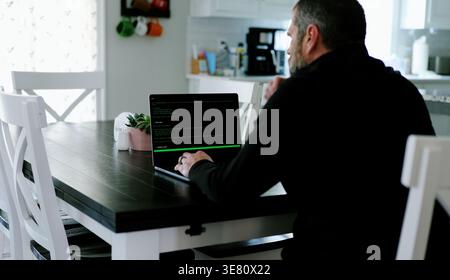 Vibe Coding Software Engineer Developing Billion Dollar Applications at Kitchen Table on Saturday Morning - AI Vibe Coder Concept Stock Photo