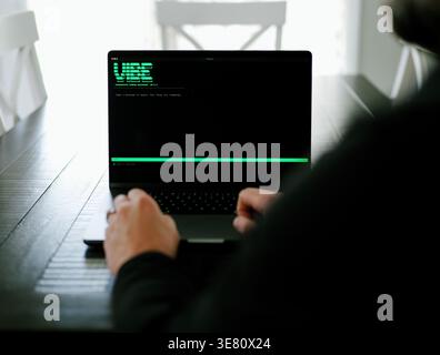 Vibe Coding Software Engineer Developing Billion Dollar Applications at Kitchen Table on Saturday Morning - AI Vibe Coder Concept Stock Photo
