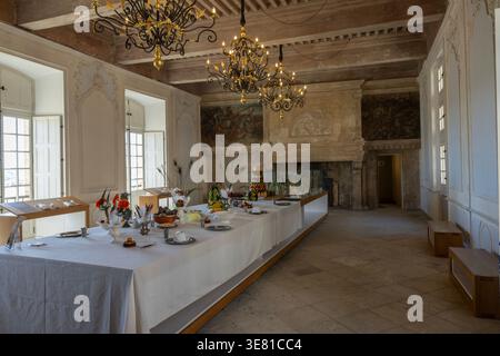 The table in the great hall of the château in Suze-la-Rousse, Drôme, France is laid and ready for guests in a décor which is regularly modified. Stock Photo