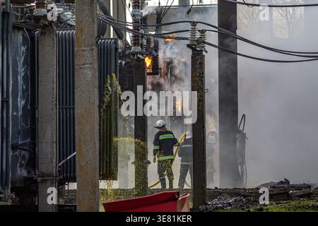 Firefighters extinguishing fire at electrical substation with burning transformer Stock Photo